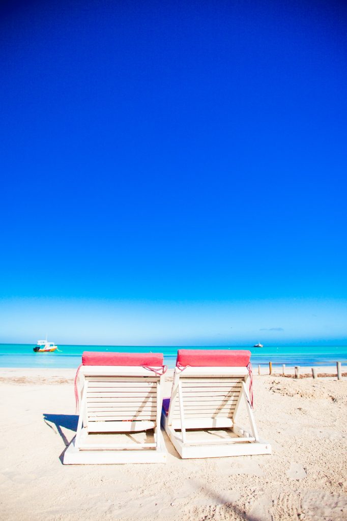 Beach sunbeds on white sand beach